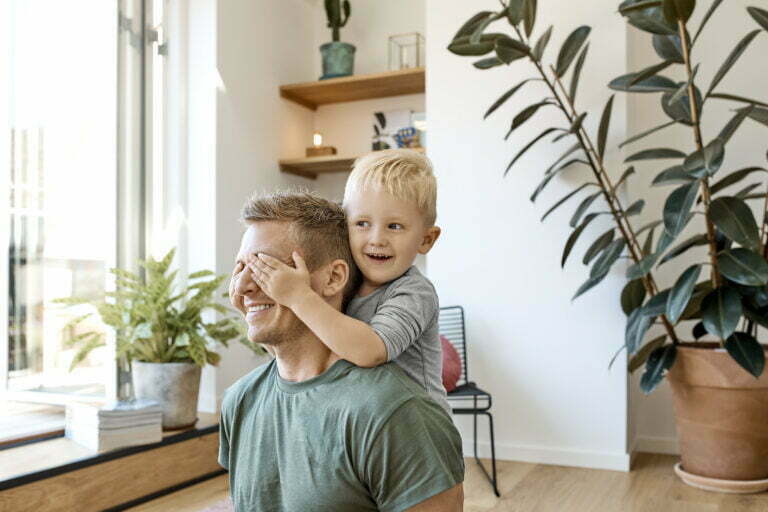Lapsi ja isä leikkimässä yhdessä iloisena uudessa asunnossa retta.fi